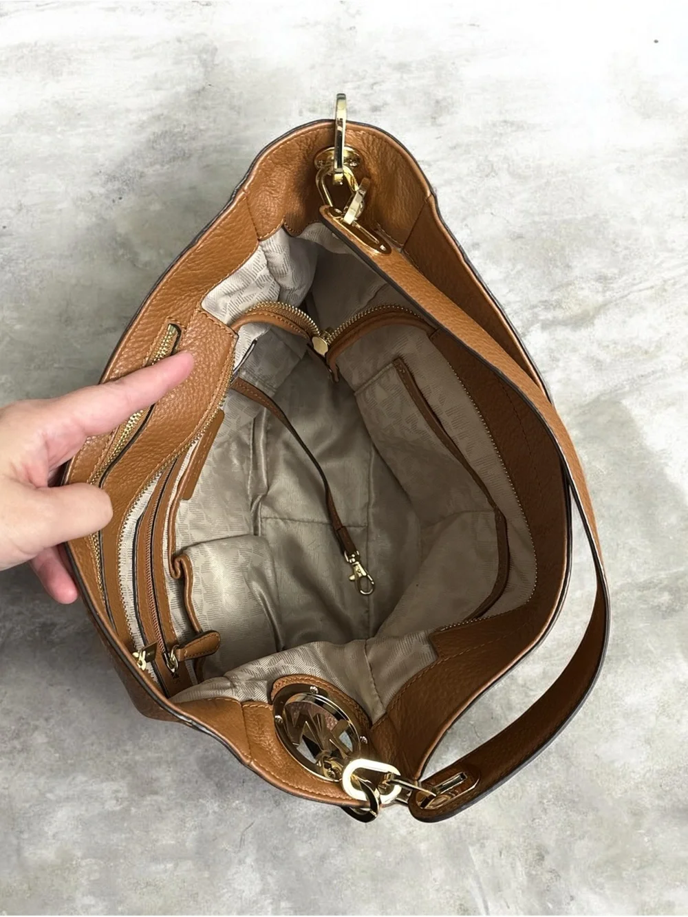 Michael Kors Cognac Pebbled Leather Shoulder Bag with Gold logo on the side.